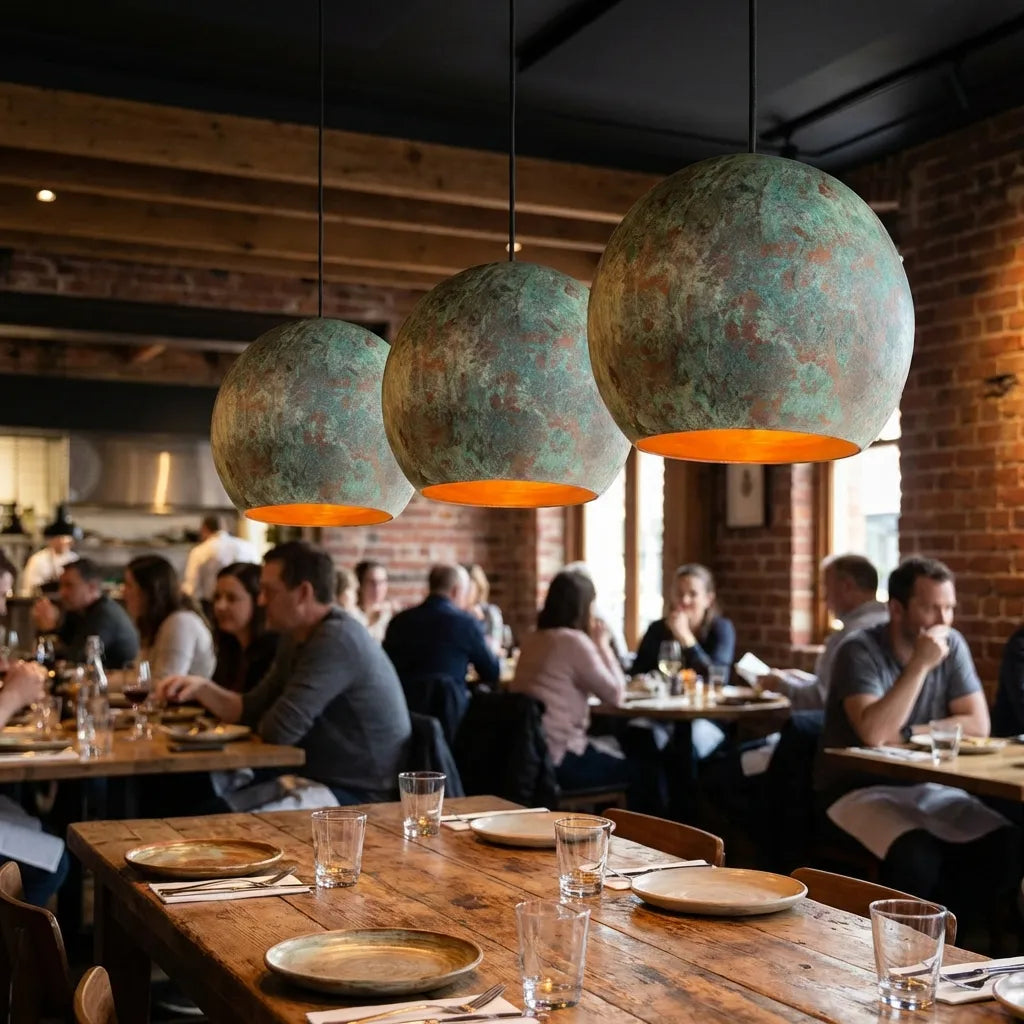 Copper patina pendant lights hanging above a dining space