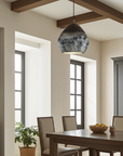 Oxidized copper dome pendant light above a wooden dining table