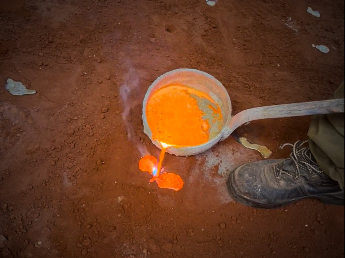 Molten copper being poured onto the ground in the CopperKesh workshop