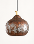 Rustic aged-copper dome pendant light on a clean studio background
