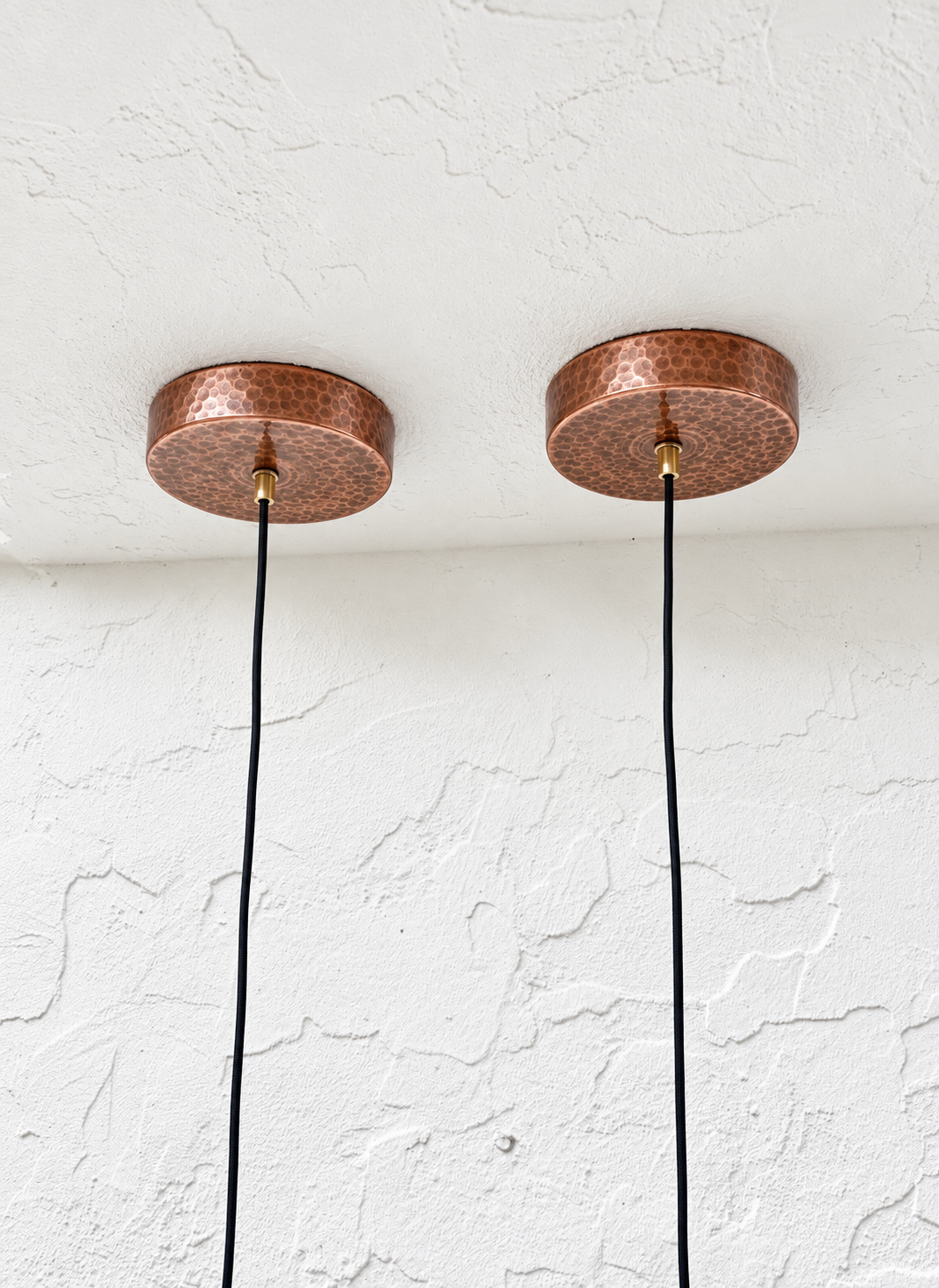 Pair of hammered aged-copper ceiling canopies with black pendant cords