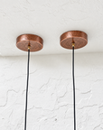 Pair of hammered aged-copper ceiling canopies with black pendant cords