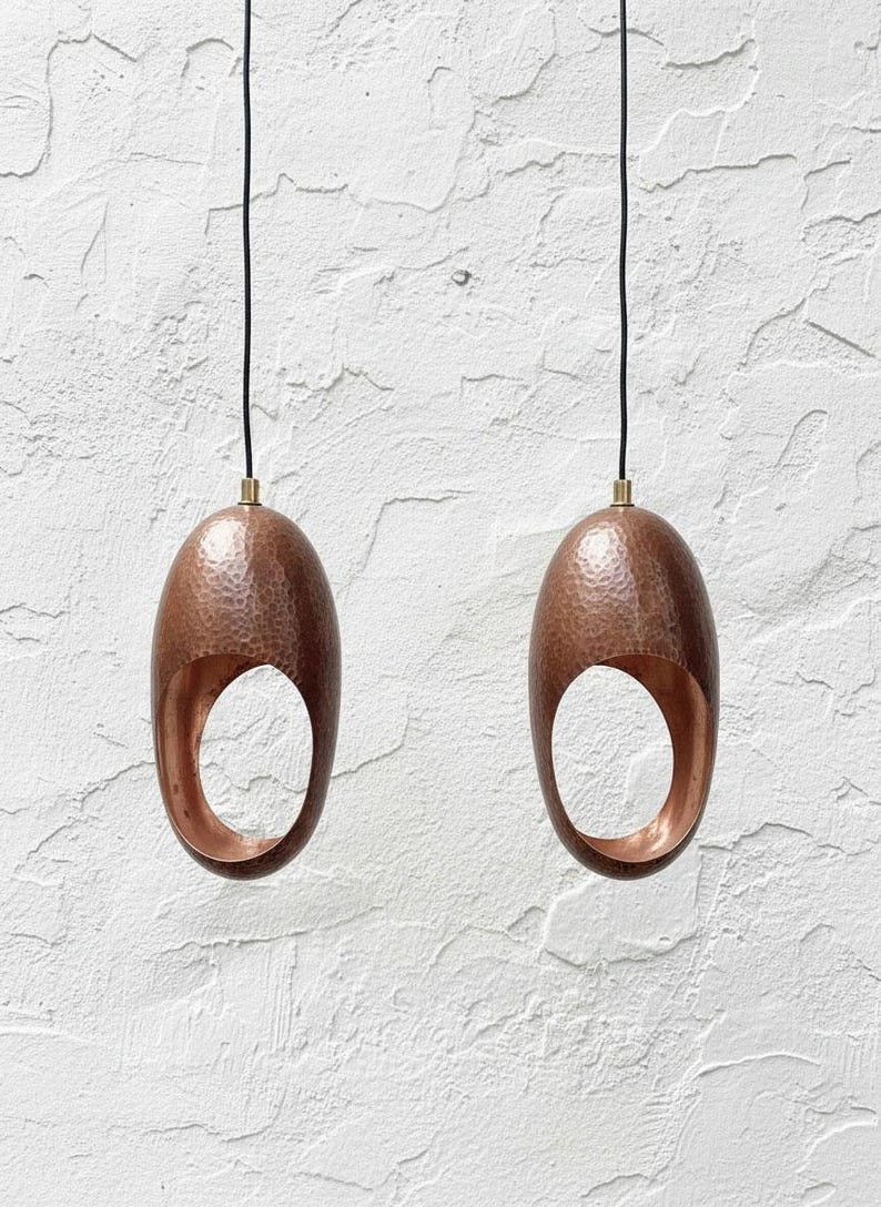 Set of two hammered aged-copper sculptural pendant lights