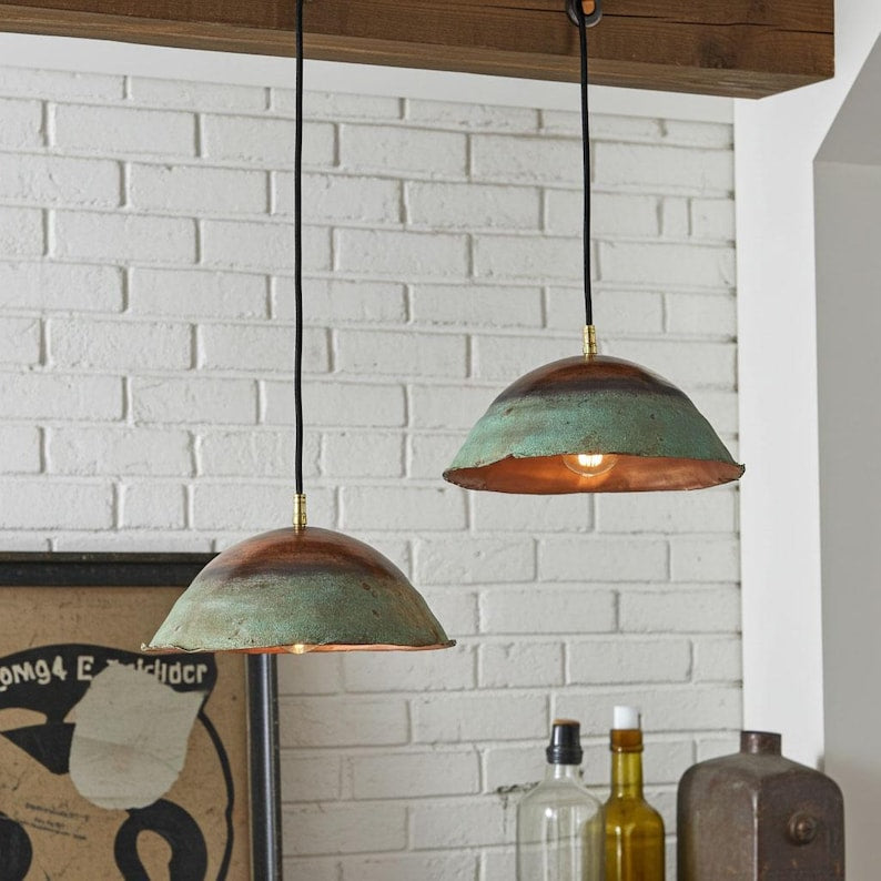 Two green patina copper dome pendant lights installed above a counter