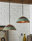 Two green patina copper dome pendant lights installed above a counter
