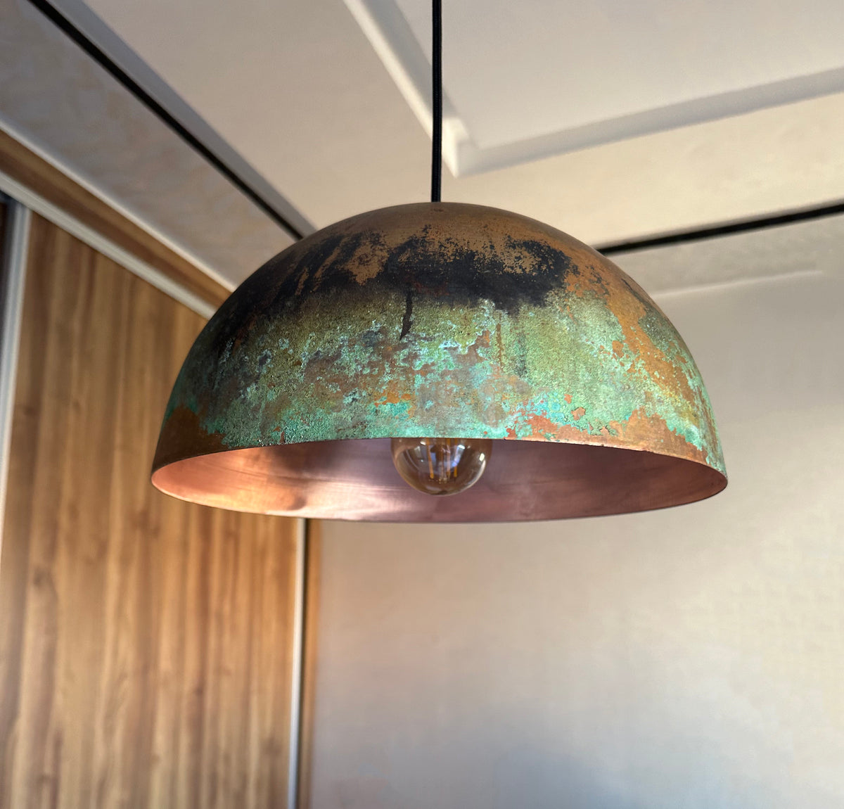 Hammered copper dome pendant light above a kitchen island