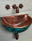 Hammered copper interior and green-patina exterior of wall-mounted bathroom sink