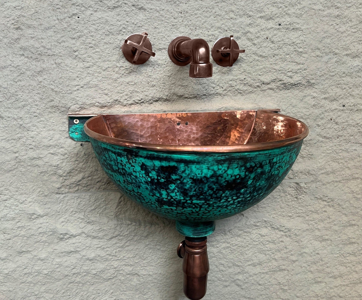 Front view of hammered copper wall-mounted sink with oxidized green exterior