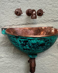 Front view of hammered copper wall-mounted sink with oxidized green exterior