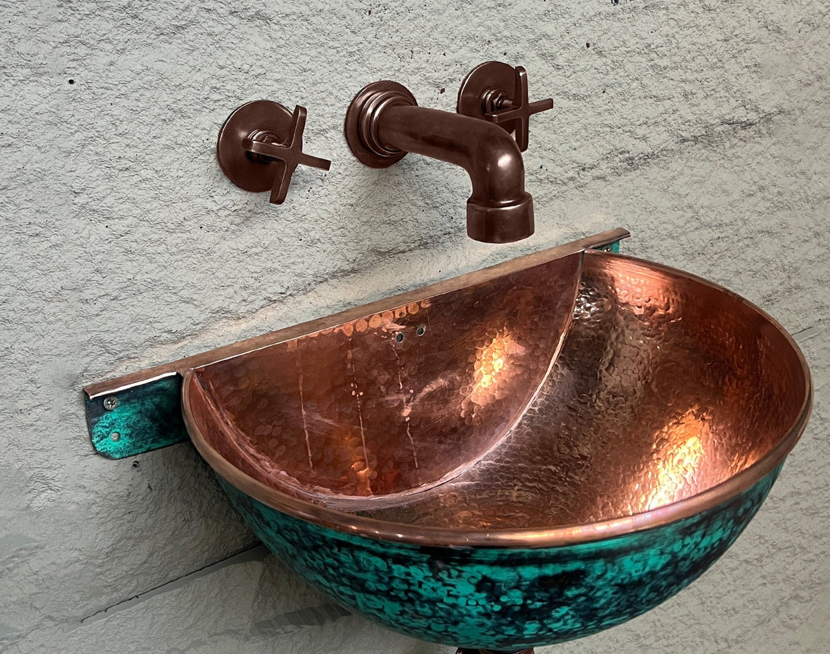 Close-up of wall-mounted hammered copper sink and matching faucet