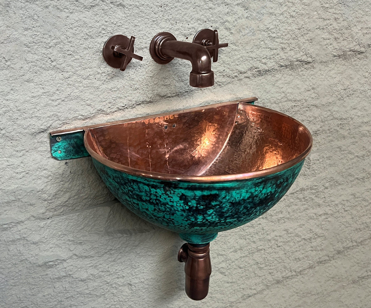 Wall-mounted green-patina copper bathroom sink with faucet and bottle trap